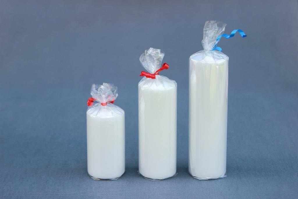trijų dydžių baltos spalvos žvakės "Cilindras", diametras 55 mm, aukštis 100 mm, 140 mm ir 180 mm.